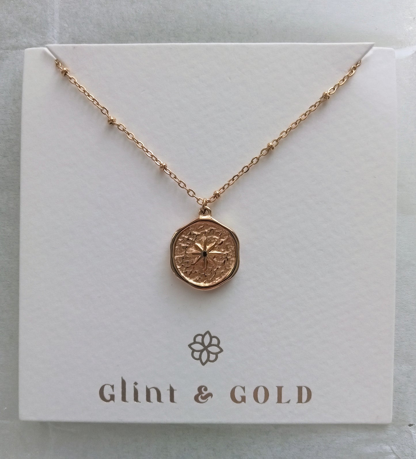 Rose gold necklace on a 'Glint & Gold' branded card