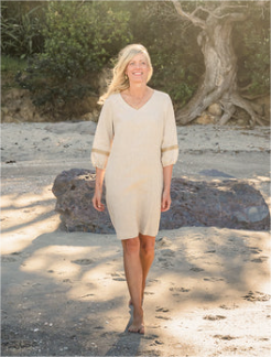 Model on beach wearing G&G Linen Dress, V-neck, 3/4 sleeves, calf length, beige, with cuff trim