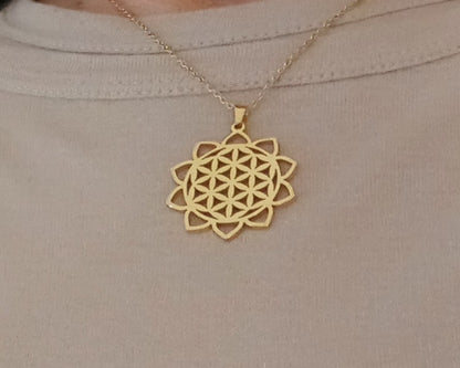 Gold necklace with a geometric pendant on a beige background