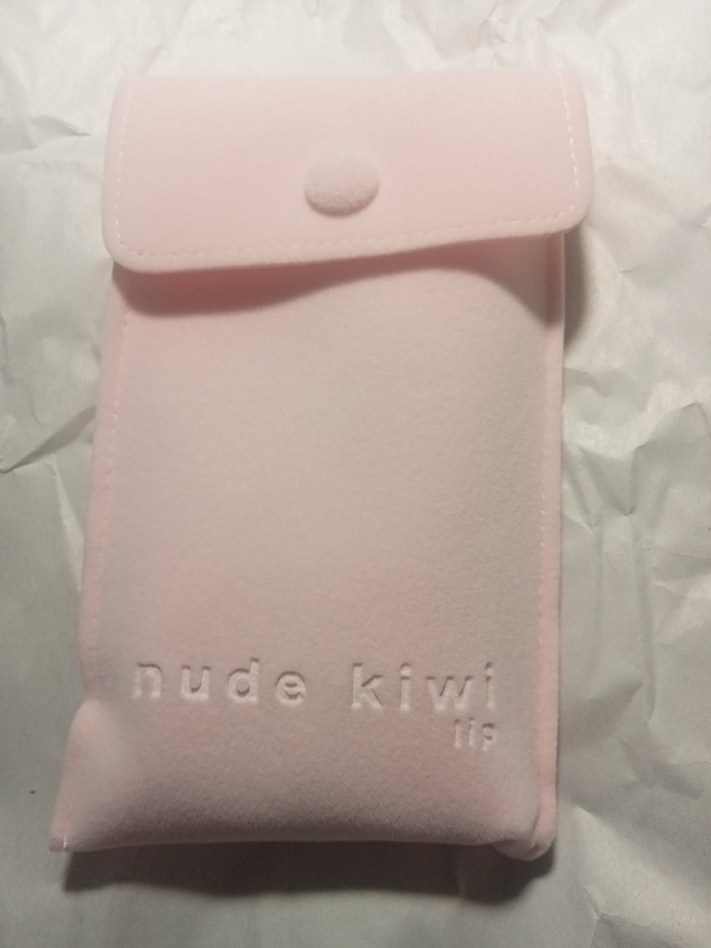 Pink suede-look pouch filled with the 2-pce lip-care items on white background.