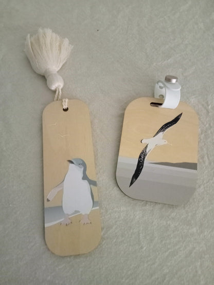 Two wooden tags with bird illustrations on a textured surface