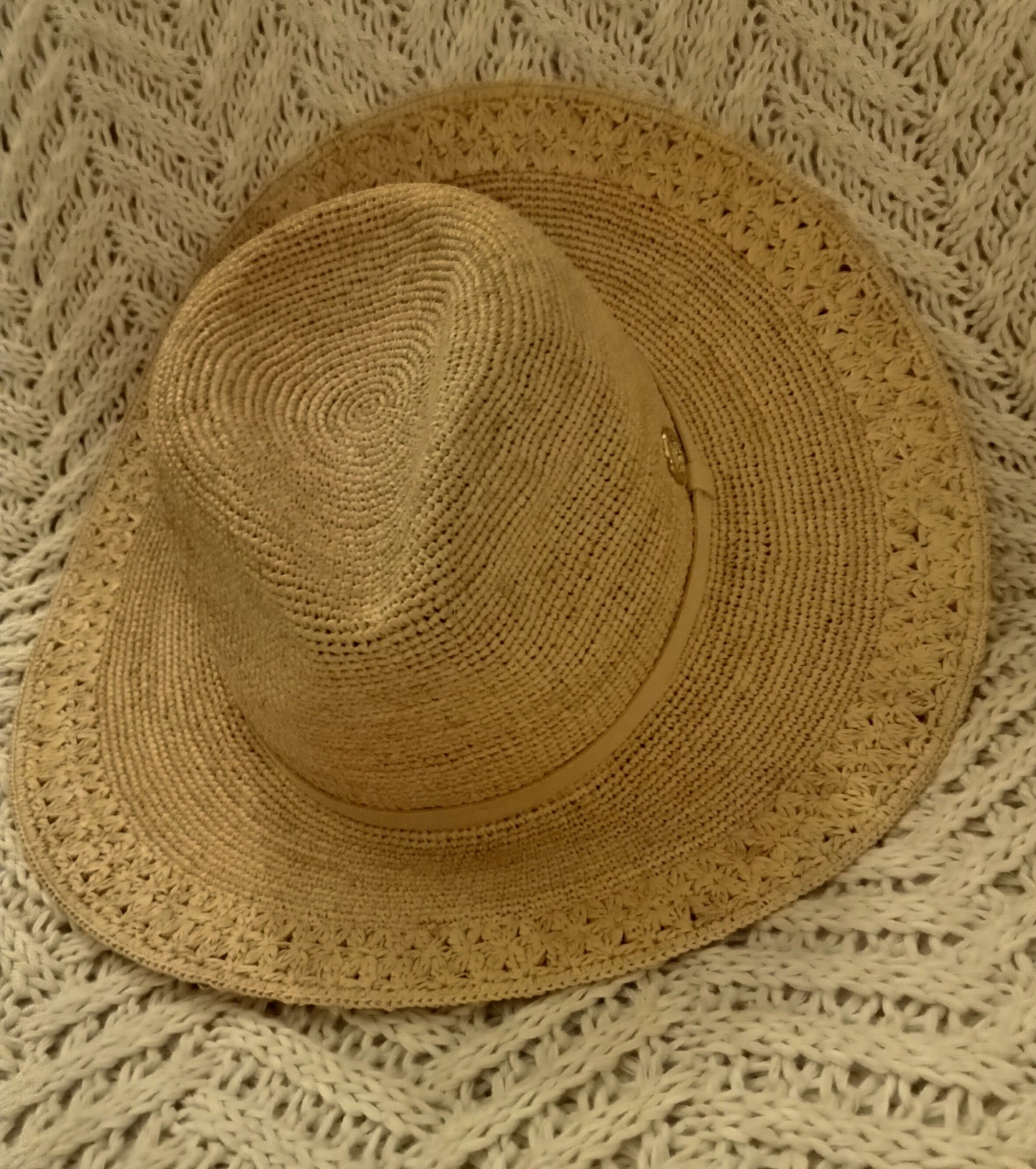 Brown raffia hat on a textured beige rug
