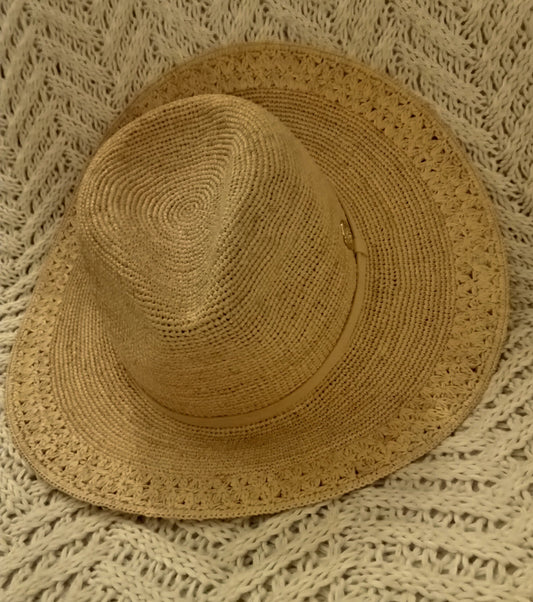Brown raffia hat on a textured beige rug