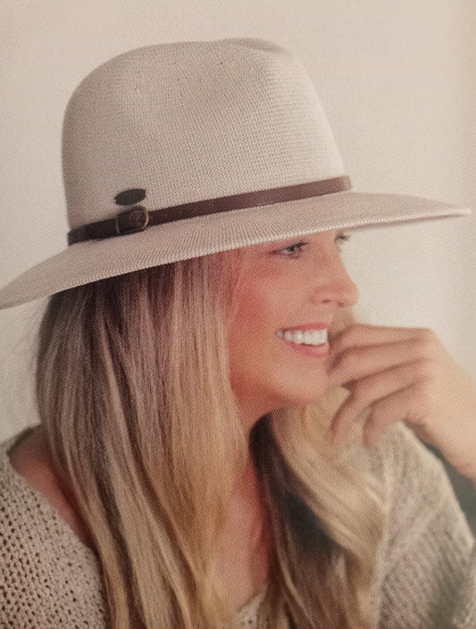Woman wearing a taupe hat with a narrow brown band against a neutral background